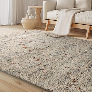 Thick textured neutral rug with subtle warm accents, styled in a minimalist room with wooden furniture and soft tones.