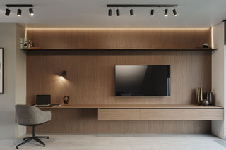 A modern home office featuring a wooden accent wall and a flat-screen television mounted on the wall.