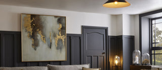 A spacious living room featuring a large, colorful painting prominently displayed on the wall.