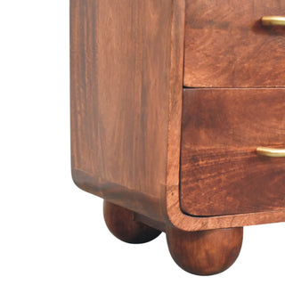 Close-up of the dark wood chest's rounded bottom corner and spherical wooden feet.