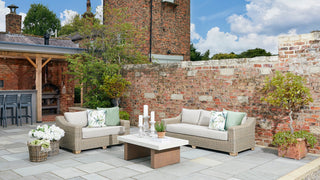 A brick wall serves as a backdrop for outdoor furniture, creating a cozy and inviting outdoor seating area.