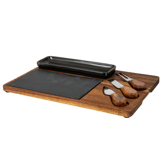 Acacia cheese board set shown at an angle, featuring slate, black ceramic dish, and recessed cutlery.