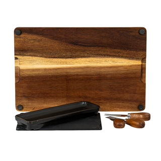 The acacia cheese board set components laid out: board showing rubber feet, slate, ceramic dish, and two wooden cheese knives.