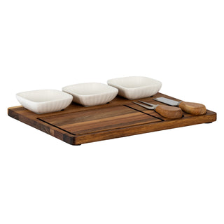 Acacia serving board set up with three white ceramic bowls and two wooden-handled cheese tools.
