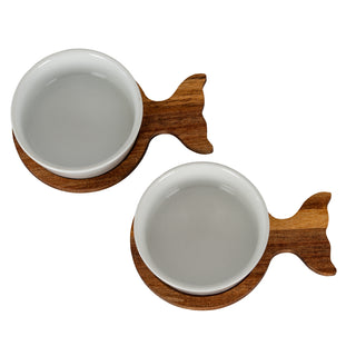Two white ceramic bowls diagonally arranged in dark wood fishtail trays.