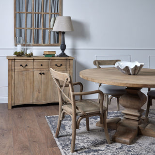 Shell bowl planter displayed on a large wooden dining table in a room setting with natural wood furniture.