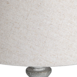 Close up of the textured light beige fabric shade showing the weave and natural flecks.