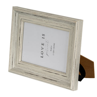 Close-up showing the distressed white wood effect texture and mitred corner joint of the frame in landscape orientation.