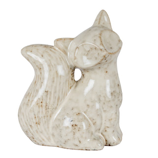 Cream speckled ceramic fox figurine sitting, facing right, against a white background.