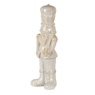 Ceramic nutcracker figure viewed from a slight angle, showing the side profile and gold detailing.