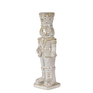 Angled studio shot of the ceramic nutcracker in a light uniform with gold detailing on the hat and boots.