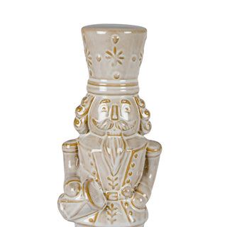 Detailed view of the nutcracker's ceramic face, uniform jacket, and ornate hat design.