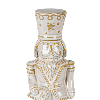 Close-up of the ceramic nutcracker's head and torso, showing the gold detailing on the uniform and hat.