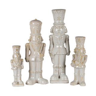 Four ceramic nutcracker figures in varying sizes and designs, finished in beige glaze with gold detailing.