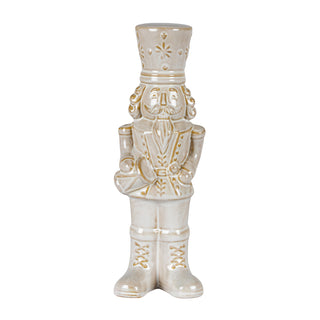 Plain front view of the beige ceramic nutcracker figure with gold detailing, holding a drum.