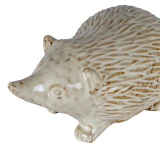 Close view of the ceramic hedgehog's face, showing the glossy finish and speckled brown markings.
