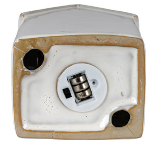 Underside detail of the ceramic townhouse base showing the exposed batteries and black on/off switch.