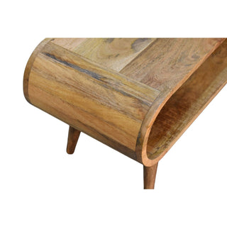 Detail of the curved end construction, showing the wood grain, internal storage, and tapered leg.
