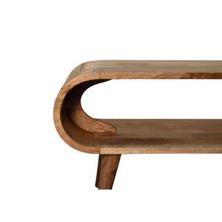 Detail shot of the rounded end of the wooden coffee table, highlighting the joint and the tapered leg.
