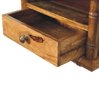 Amber oak bedside drawer partially open, showing the metal pull, internal construction, and natural wood knot.