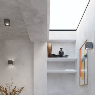Multiple anthracite quad lights installed on the ceiling and walls of a modern grey hallway.