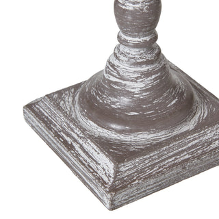 Detail of the square base and lower turned column, highlighting the chipped grey and white paint.