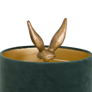 Close-up of the antique gold hare ears emerging from the dark green velvet shade, showing the internal gold lining.