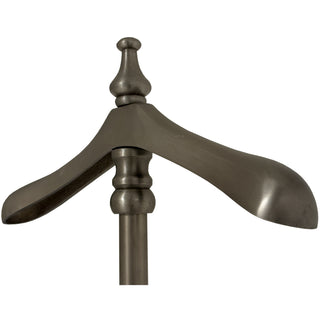 Detail of the antiqued metal coat hanger top and the decorative finial above the vertical pole.