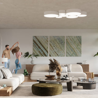 Organic cluster of illuminated white circular ceiling lights in a contemporary living room above neutral sofas.