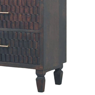 Lower right corner of the dark wood chest showing the textured drawers and turned wooden legs.
