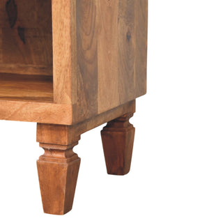 Detail of the golden teak unit showing the carved, turned feet and the base of the open shelf.