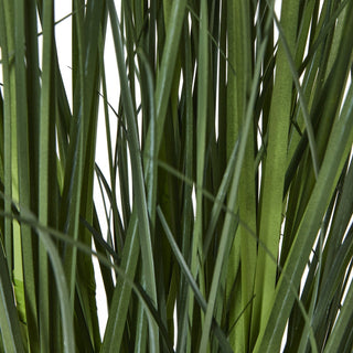 Close detail of the artificial agapanthus plant's long, dark green, grass-like leaves.