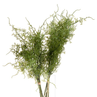 Close-up of the dense, feathery green artificial fern foliage in a tall glass vase.