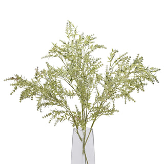 Artificial broom stem displayed upright in a tall, clear glass vase against a white studio background.