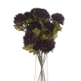 A full bouquet of artificial chocolate chrysanthemums and green leaves displayed in a clear glass vase.