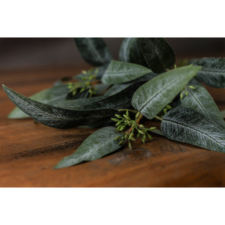 Close detail of the artificial eucalyptus spray showing the seed buds and dark foliage.