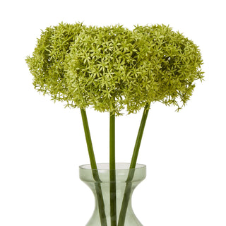 Three artificial green allium stems arranged in a pale green glass vase.