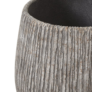 Close detail of the taupe planter's rough, vertically grooved texture and the dark interior rim.