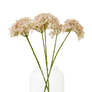 Three artificial pink crown hydrangea stems arranged in a clear glass vase on a white background.