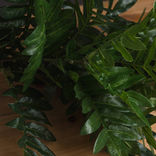 Close detail of the dense artificial green foliage bunch, showing multiple layers of leaves and stems.