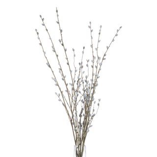 Full bunch of artificial pussy willow stems with grey catkins displayed upright in a clear glass vase on a white background.
