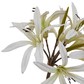 Close detail of the artificial white lily petals, showing texture, dark stamens, and green buds.