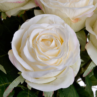 Detailed view of the artificial rose head, highlighting the creamy white petals and slight pink edges.