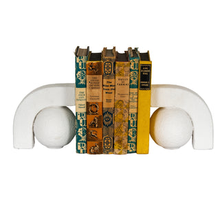 Straight-on view of the textured ashen white bookends supporting six books with colourful spines.