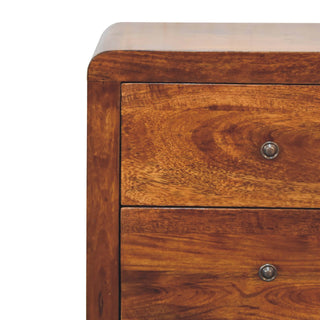 Close-up detail of the rounded top corner, showing the top two drawers and circular metal handles.