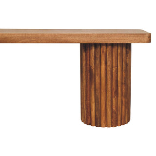 Detail of the dark wood bench seat and the cylindrical leg made of vertical fluting.