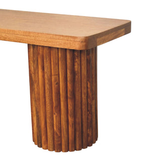 Close-up of the smooth wooden seat edge meeting the cylindrical support made of vertical wooden fluting.