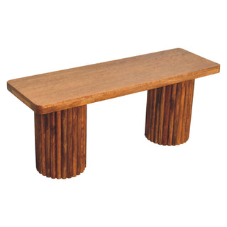 Smooth wooden seat of the Astoria bench supported by two chunky legs made of vertical fluting.