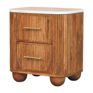 Full front view of the wooden bedside table with white marble top and brass bar handles.