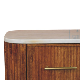 Close-up of the rounded white marble top edge, reeded wood cabinet, and brass bar handle.